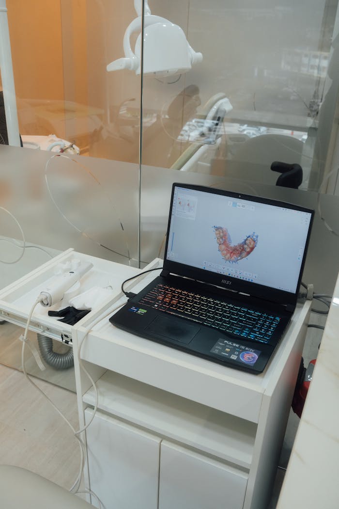 Modern dental office setup with a laptop displaying dental imaging software.