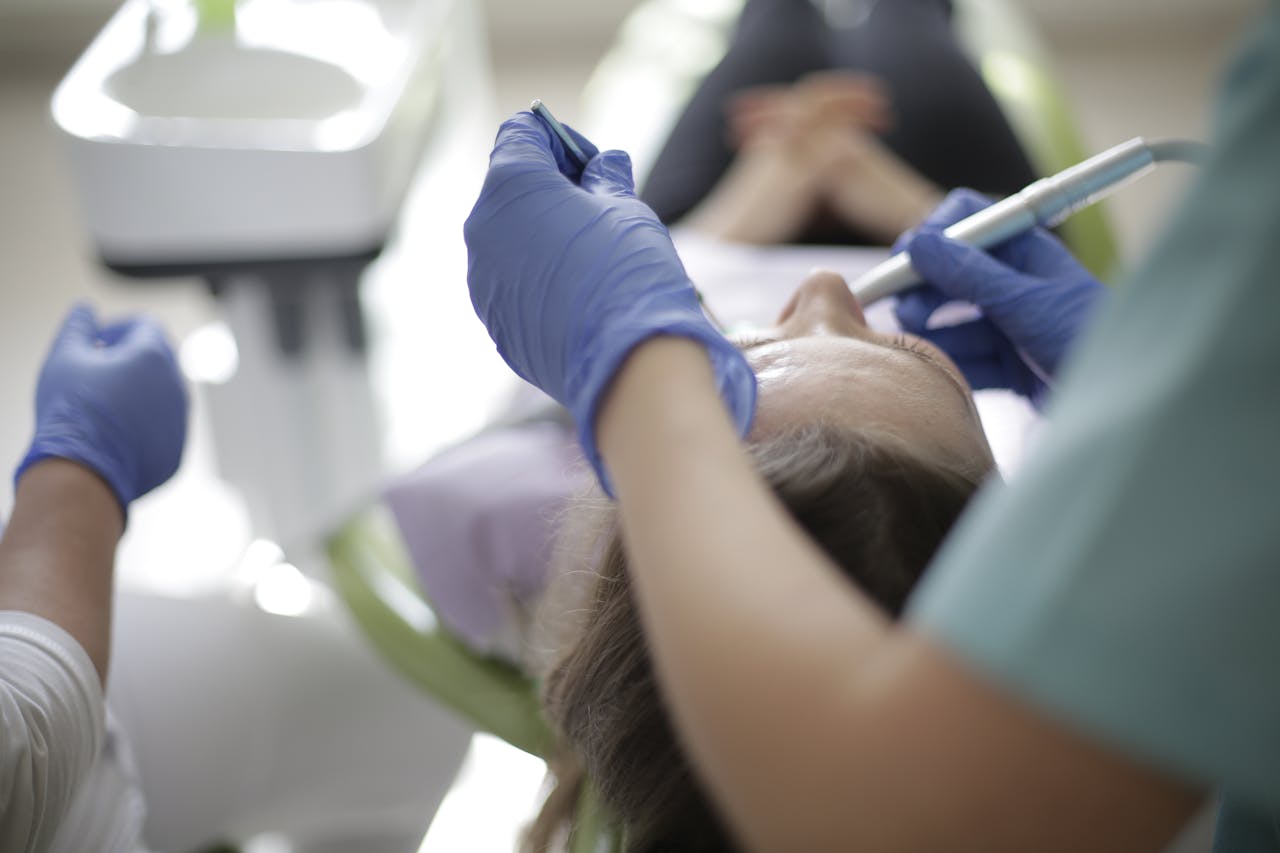 Patient undergoing dental procedure with dentist in modern clinic, focusing on oral care.