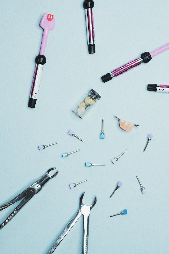 Flat lay of dental tools and orthodontic instruments on a light blue background.